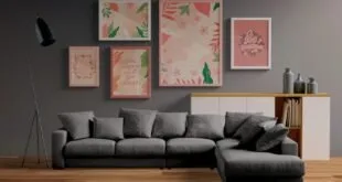 Sala com sofá cinza em L e conjunto de quadros coloridos pendurados na parede