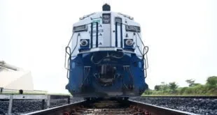 Locomotiva azul e branca parada sobre trilhos, vista de frente