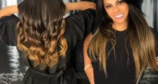 Mulher de costas exibe cabelo longo alongado ao lado de outra mulher em salão de beleza