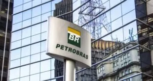 Totem com o logotipo da Petrobras diante de prédio de fachada espelhada