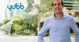 Homem sorridente de camisa azul ao ar livre, imagem ilustrativa sobre investimentos