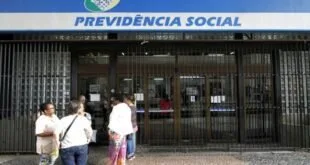 Pessoas em frente a agência com o letreiro 'Previdência Social'