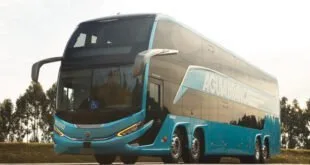Ônibus rodoviário de dois andares branco e azul em pista de teste