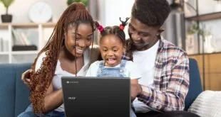 Casal e criança sorrindo no sofá diante da tela de um notebook Acer aberto