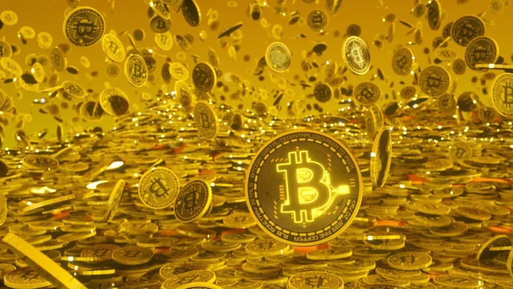 Moedas douradas com o símbolo do bitcoin caindo sobre uma pilha de moedas