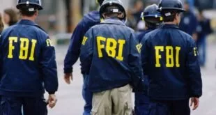 Agentes de costas com jaquetas escuras e a sigla 'FBI' estampada