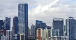 Arranha-céus à beira-mar sob céu nublado em cidade litorânea