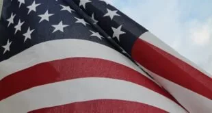 Bandeira dos Estados Unidos tremulando em close com o céu ao fundo