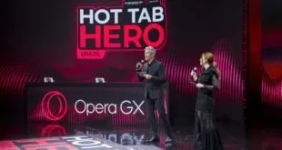 Dois apresentadores no palco diante de telão com os letreiros 'HOT TAB HERO' e 'Opera GX'