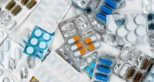 Cartelas de comprimidos e cápsulas espalhadas sobre superfície branca