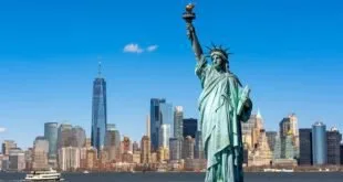 Estátua da Liberdade diante do horizonte de arranha-céus de Nova York e do rio
