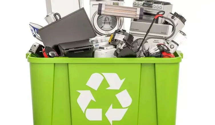 Lixeira verde de reciclagem cheia de aparelhos e peças eletrônicas descartadas