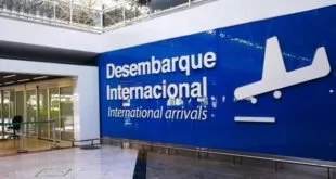 Painel azul com os dizeres 'Desembarque Internacional' em saguão de aeroporto