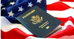 Passaporte azul dos Estados Unidos apoiado sobre a bandeira norte-americana