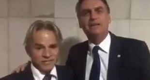 Dois homens de terno lado a lado em quadro de vídeo com fundo escuro