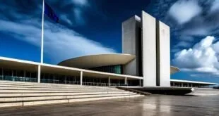 Prédio modernista de concreto branco com marquise curva e explanada vazia sob céu azul