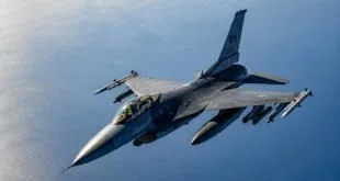 Caça militar com mísseis sob as asas voando sobre o mar aberto