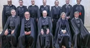 Grupo de magistrados de toga preta posando para retrato oficial em tribunal