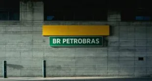 Placa verde com a inscrição 'BR Petrobras' em fachada de concreto de prédio