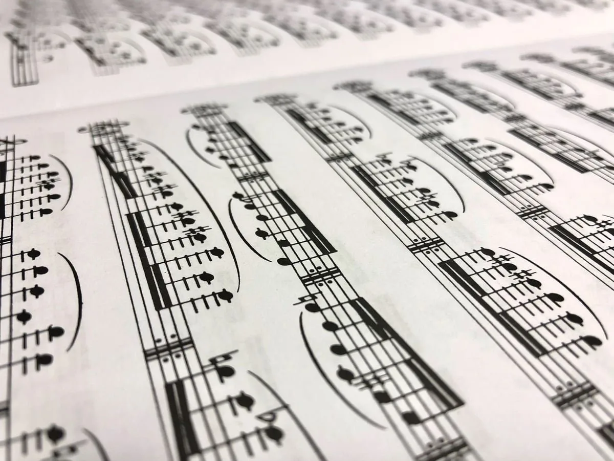 Partitura musical aberta sobre uma mesa, associada à execução de um hino