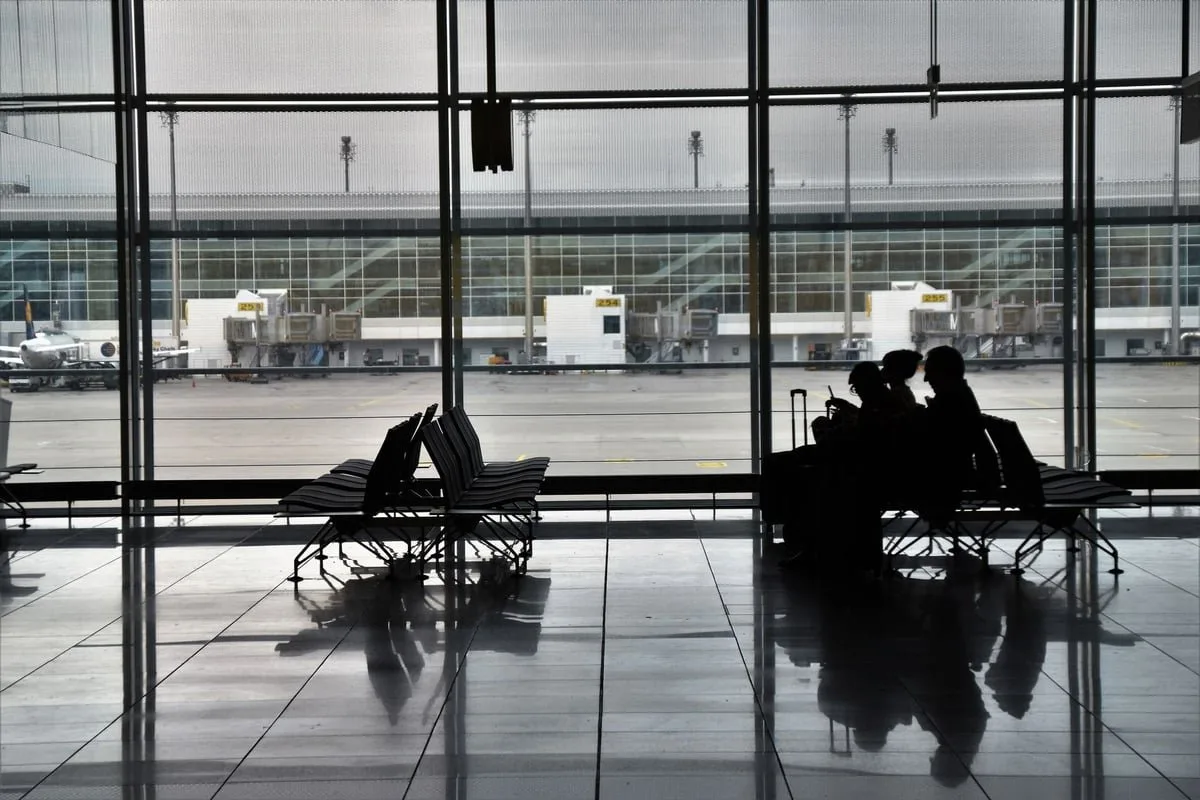 Grupo de pessoas com malas em terminal de viagem em referência ao Dia Internacional do Migrante