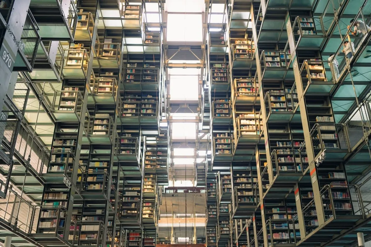 livros abertos empilhados sobre mesa de biblioteca com luz natural