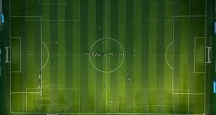 Atleta em campo esportivo durante treino, com bola aos pés