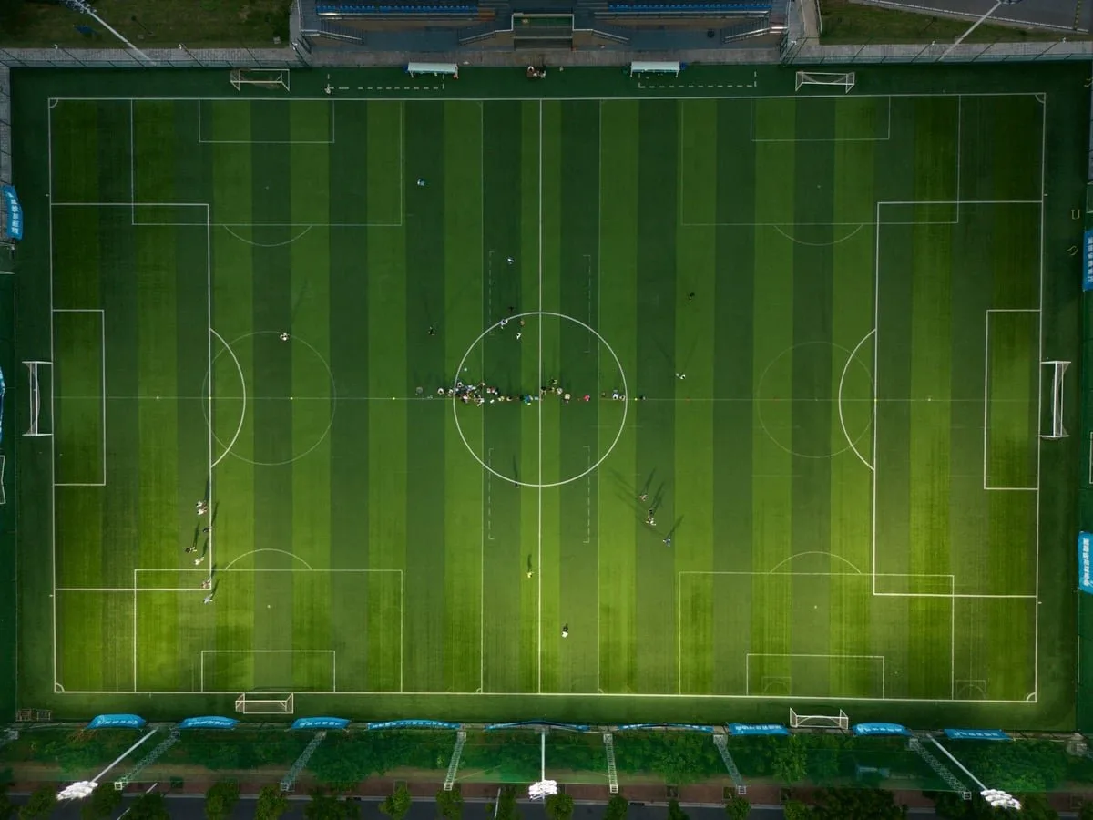 Atleta em campo esportivo durante treino, com bola aos pés