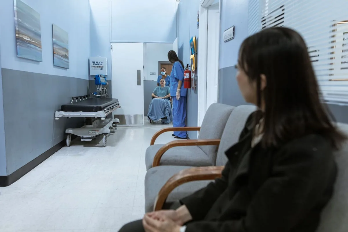 Profissional de saúde com máscara e jaleco em corredor de hospital durante a pandemia