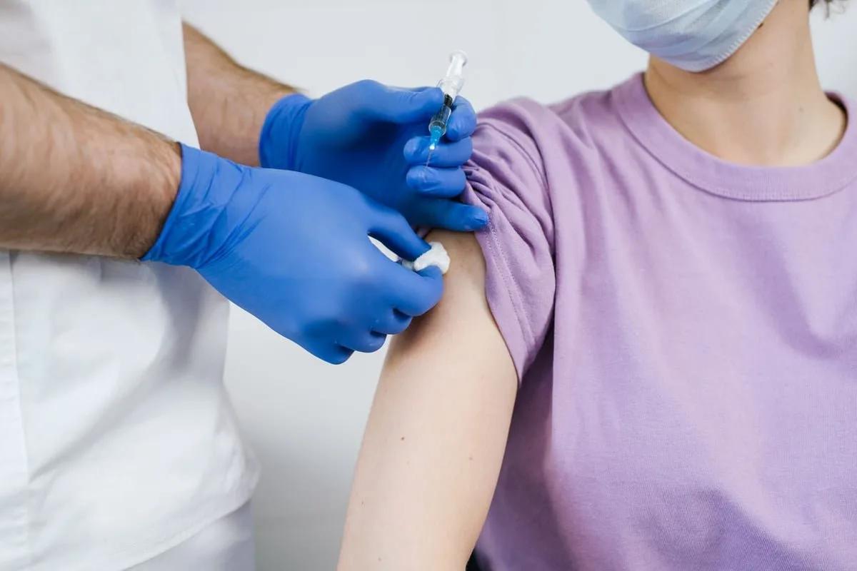 Recém-nascido recebendo aplicação de vacina no braço em maternidade