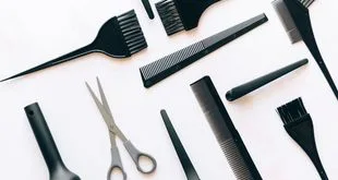 Instrumentos de cabeleireiro, barbeiro e manicure organizados sobre uma bancada de salão de beleza