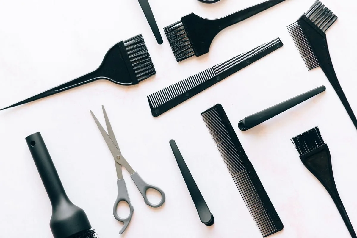 Instrumentos de cabeleireiro, barbeiro e manicure organizados sobre uma bancada de salão de beleza