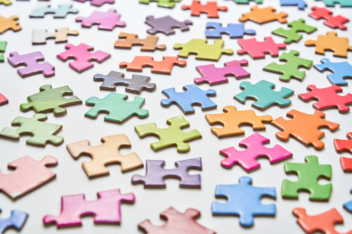 Quebra-cabeça colorido em mesa, símbolo comum de conscientização sobre espectro autista