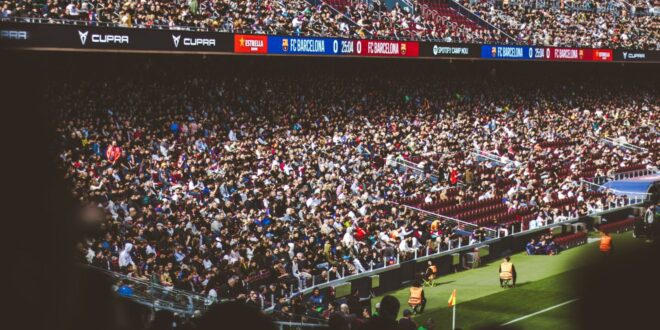 Multidão animada assistindo a uma partida de futebol no Estádio Camp Nou, em Barcelona