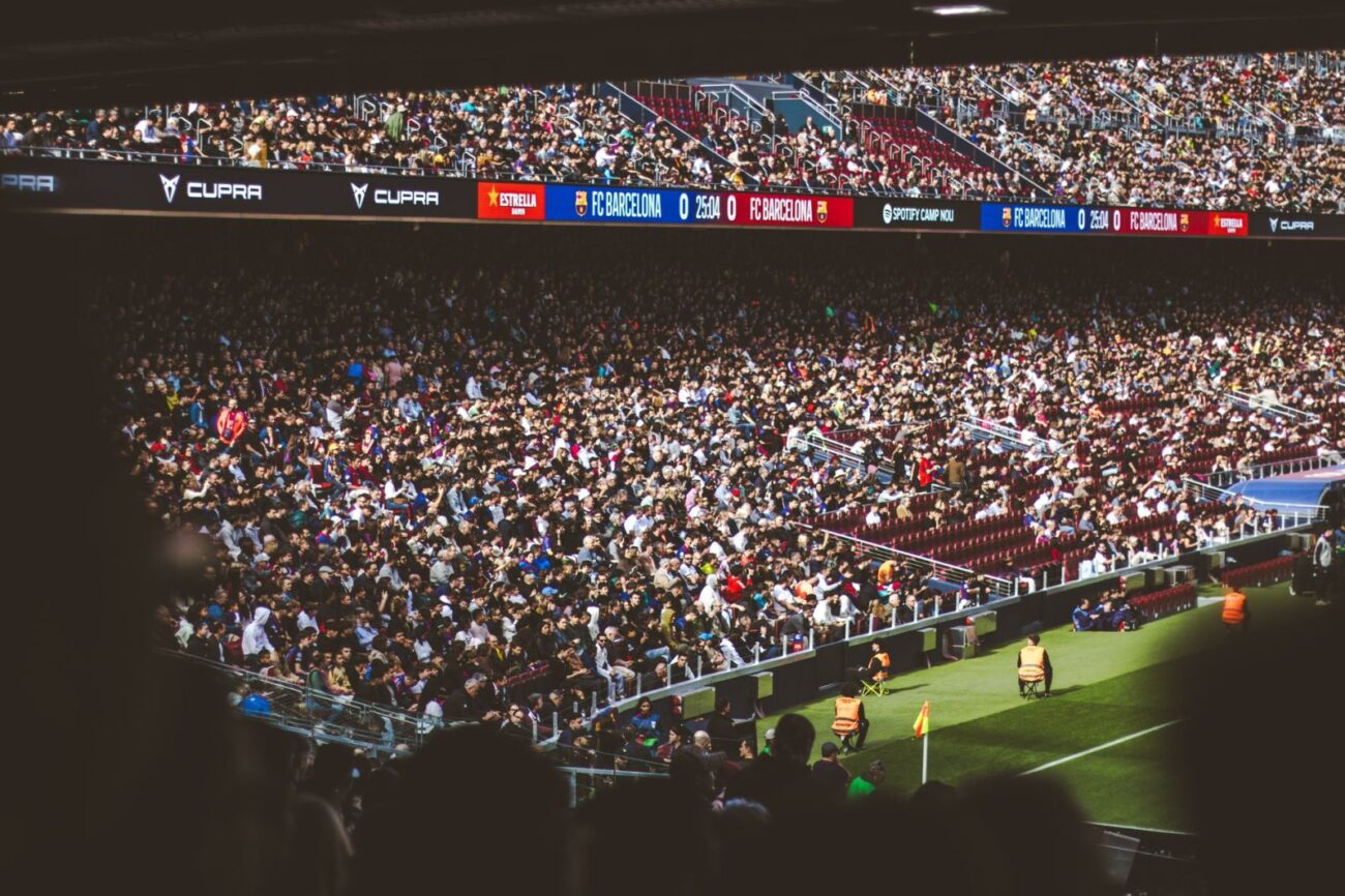 Multidão animada assistindo a uma partida de futebol no Estádio Camp Nou, em Barcelona