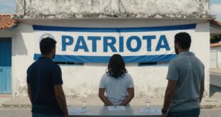 Três pessoas em pé diante de uma mesa, observando um banner azul e branco com texto em um edifício