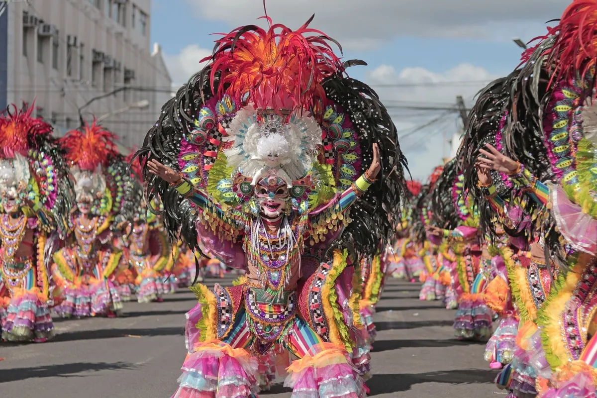 Barracão de escola de samba com fantasias coloridas penduradas