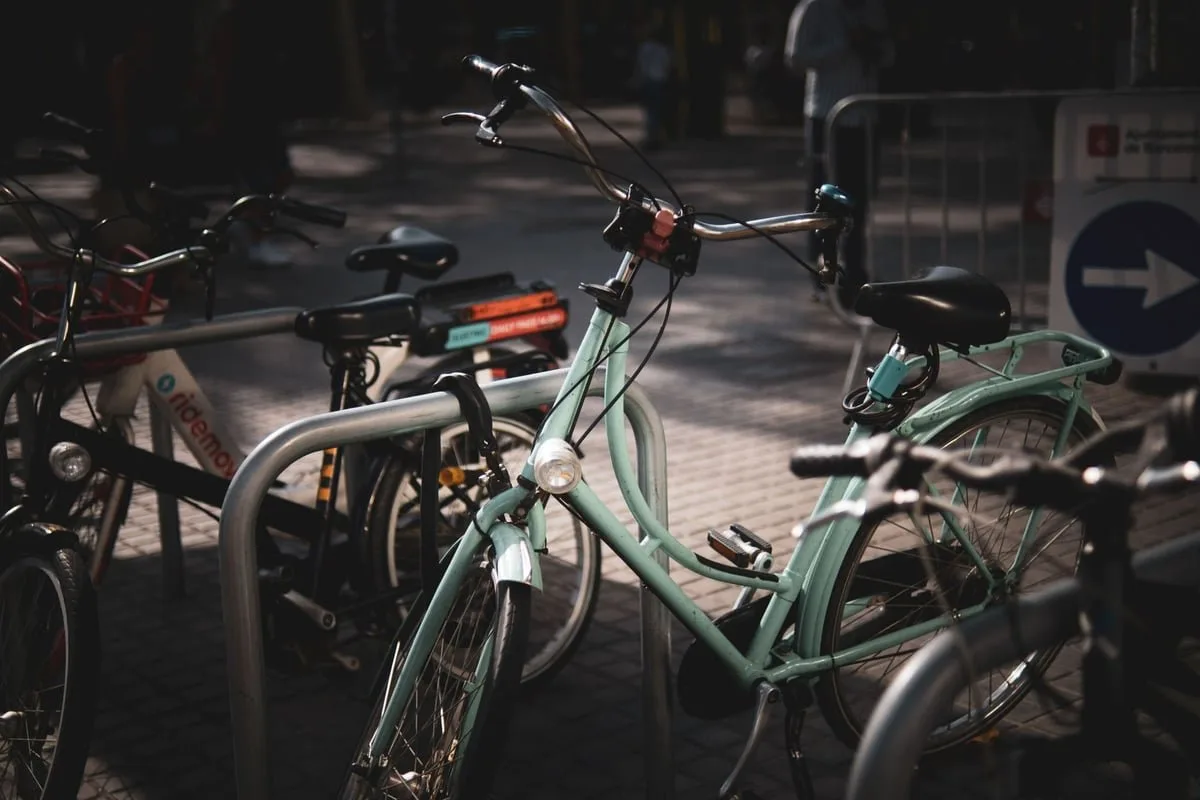 Carteiro em bicicleta entregando envelope na porta de uma casa em rua residencial