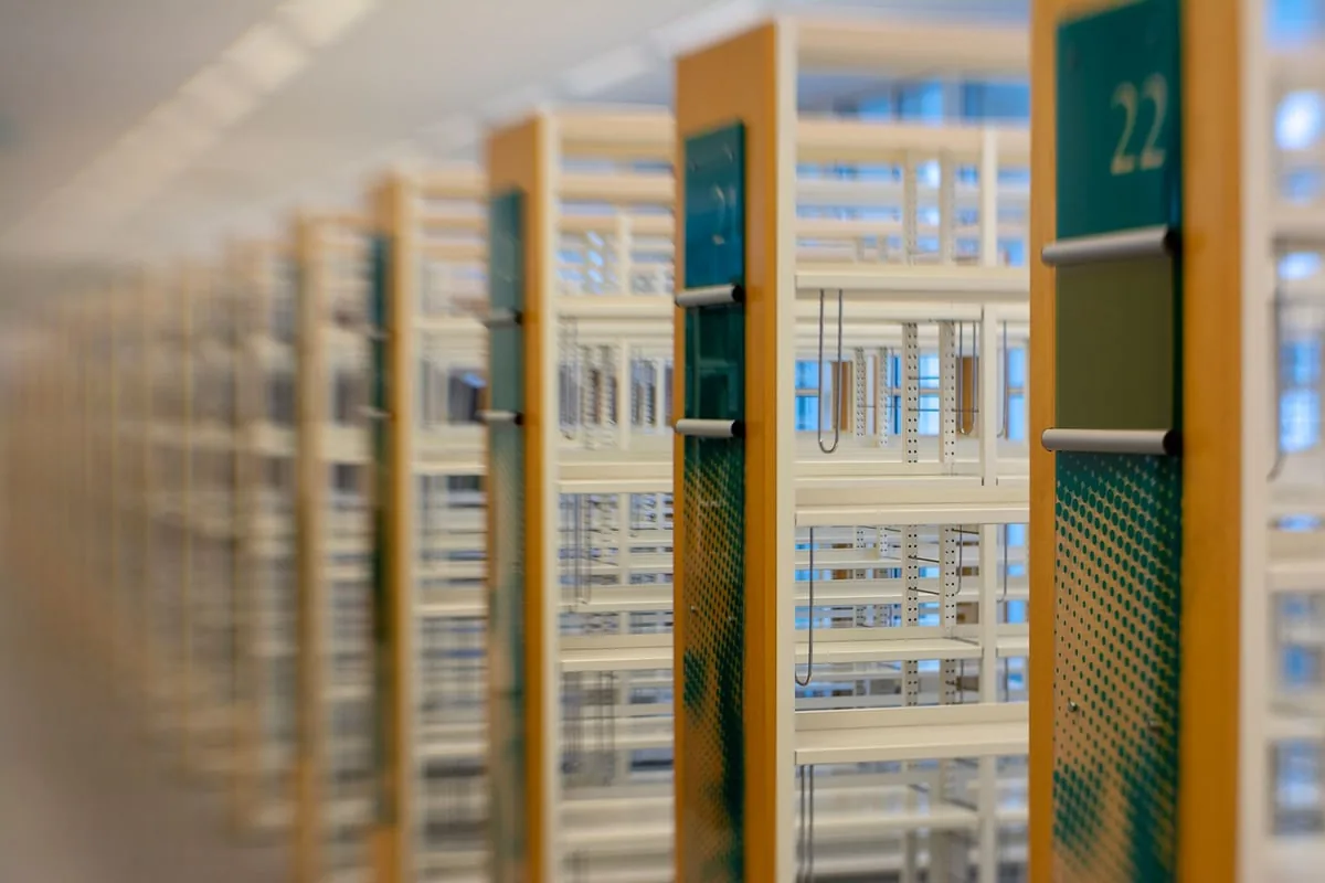 Escrivaninha de madeira com máquina de escrever e pilha de livros