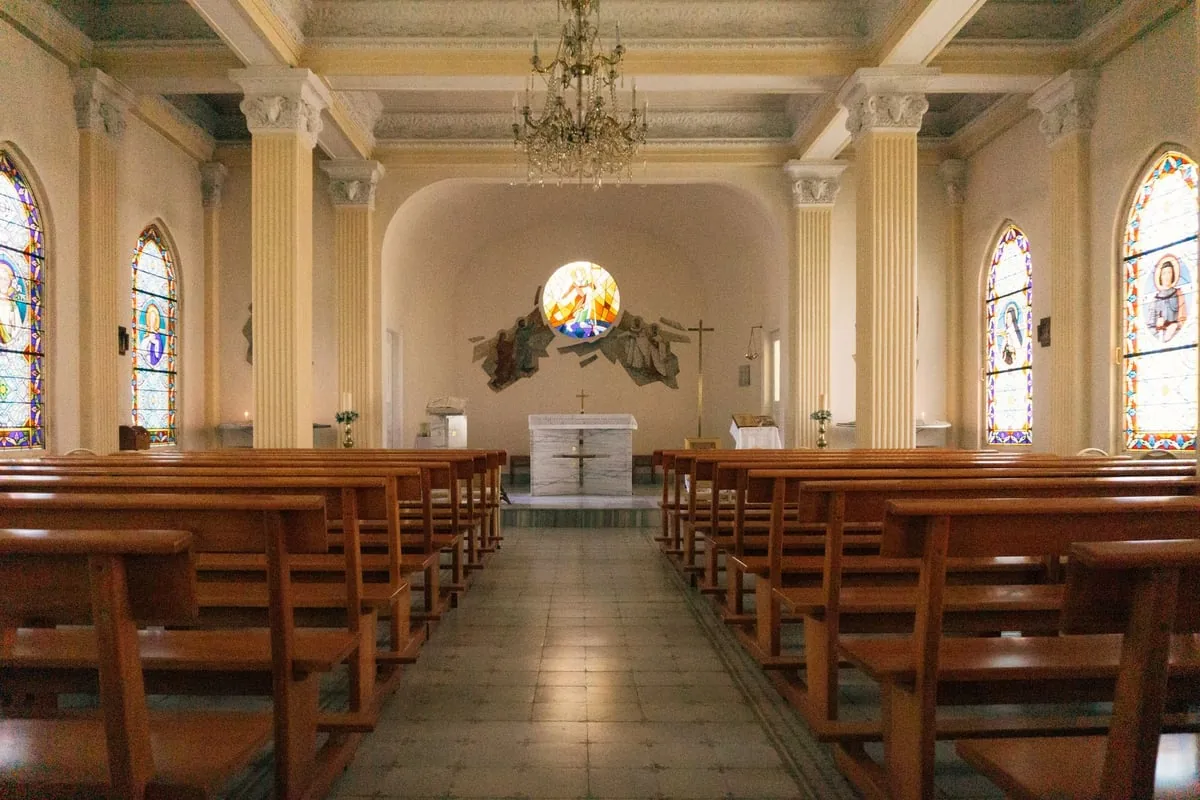 bengala branca apoiada em banco de madeira de igreja vazia
