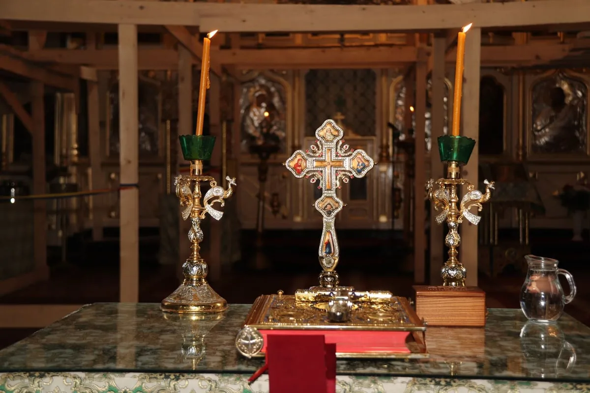 Coroa do Advento com quatro velas acesas sobre mesa decorada