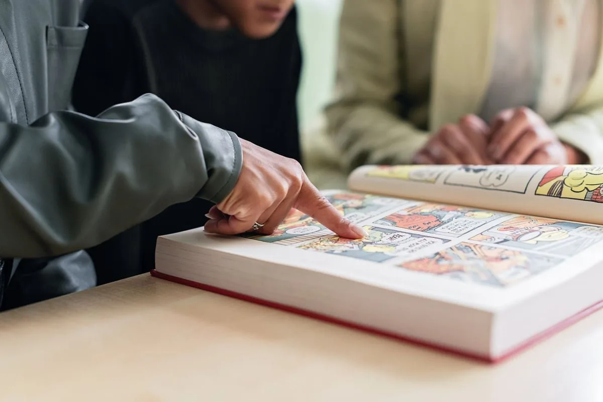 Revista de história em quadrinhos aberta sobre uma mesa de leitura