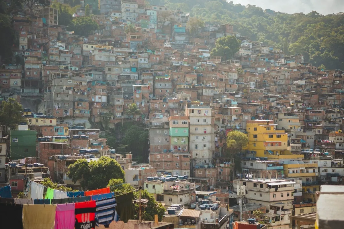 Mãos de voluntária pesando bebê em balança simples de comunidade