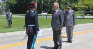 Cadete em uniforme de gala presta continência a autoridades em pátio de escola militar