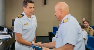 Dois oficiais da Marinha se cumprimentam durante entrega de premiação em auditório