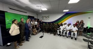 Grupo de militares e civis posa para foto em auditório de empresa de energia