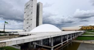 Prédio do Congresso Nacional com cúpula branca e torres gêmeas sob céu nublado
