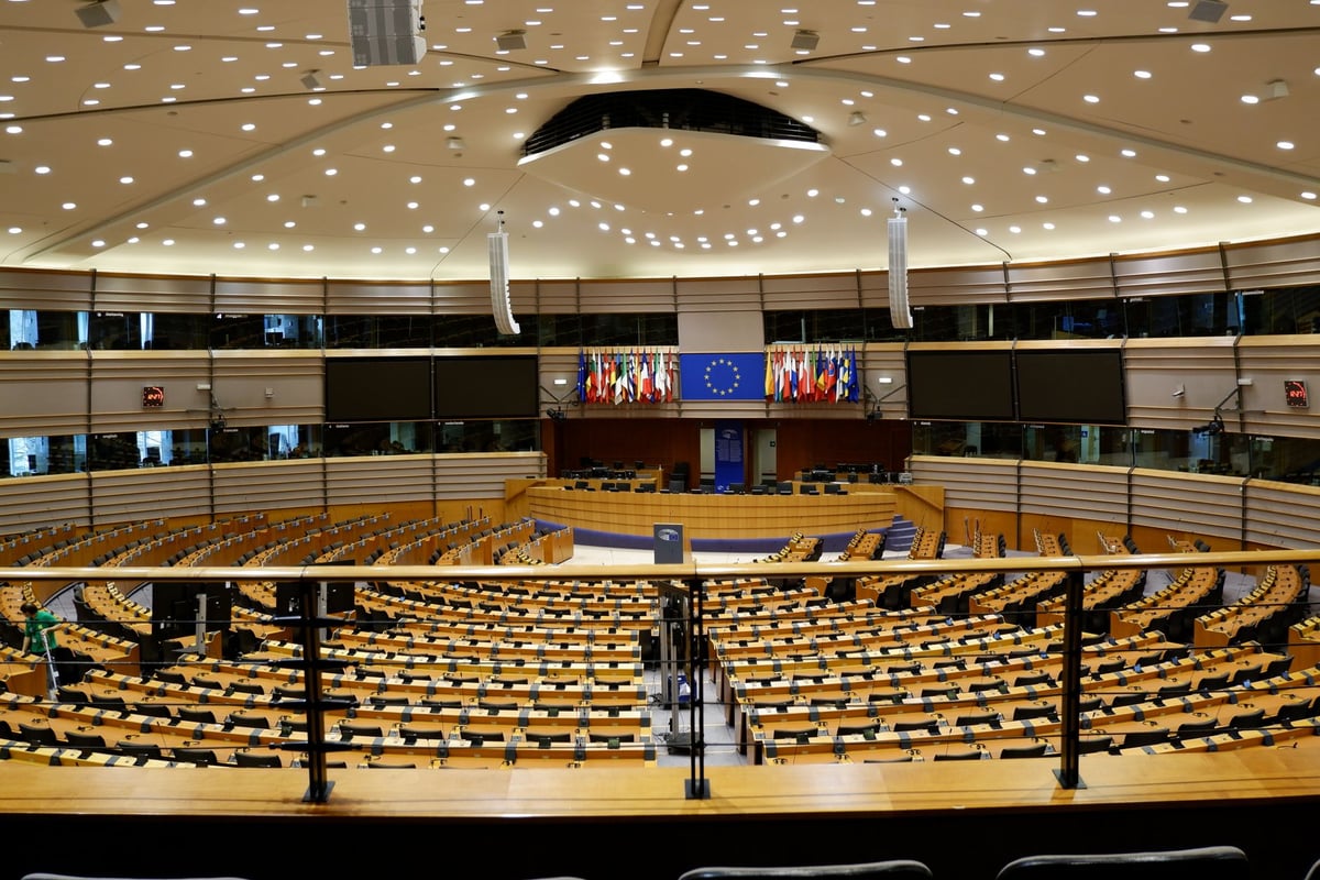 Plenário de assembleia internacional vazio, cadeiras e microfones alinhados