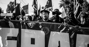 Cartaz de protesto erguido em manifestação por direitos trabalhistas