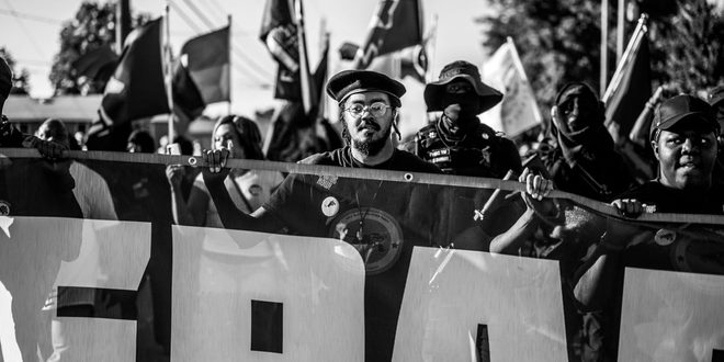 Cartaz de protesto erguido em manifestação por direitos trabalhistas